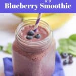 blueberry smoothie in glass mug topped with fresh blueberries