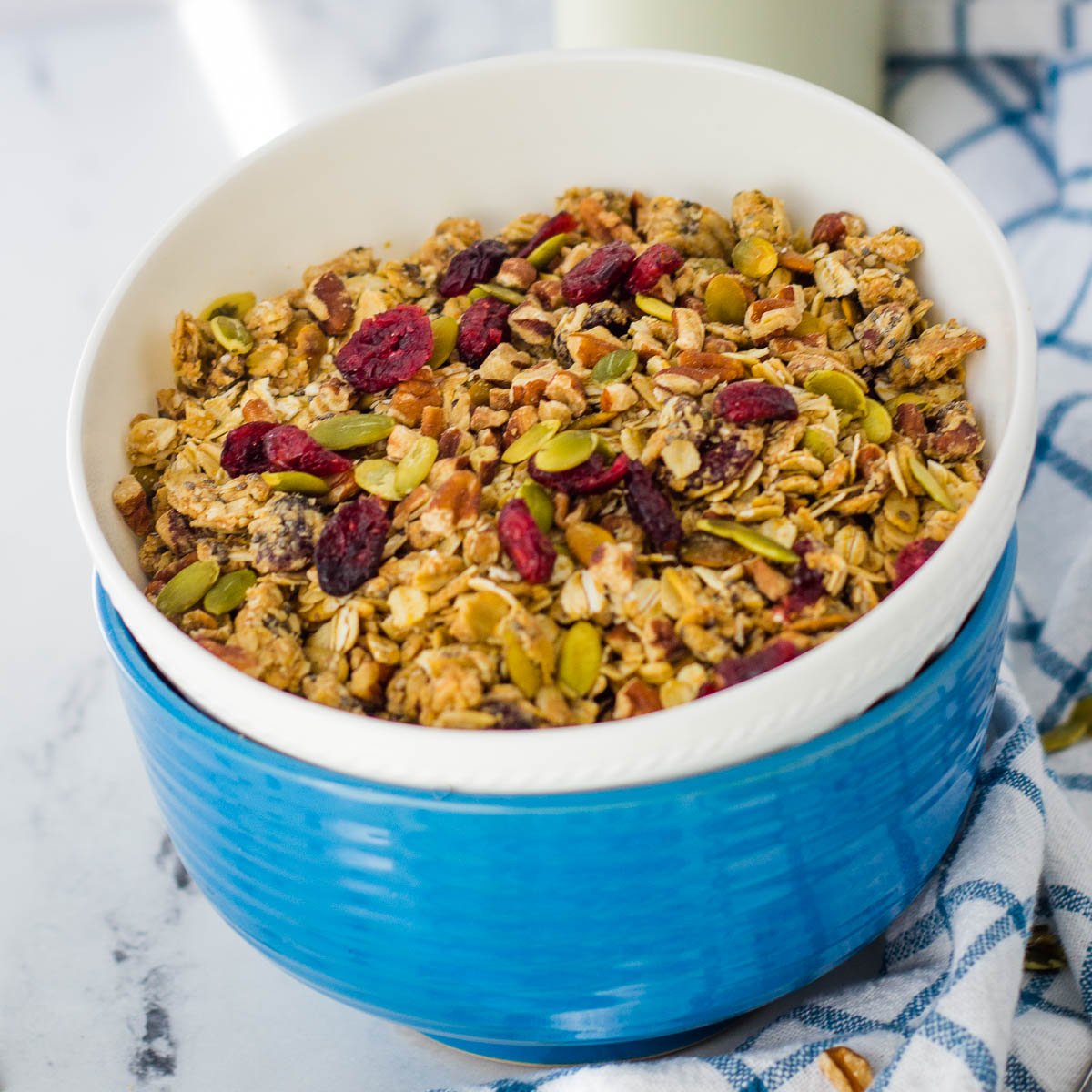 Sugar free granola with cranberries in blue and white bowls. 