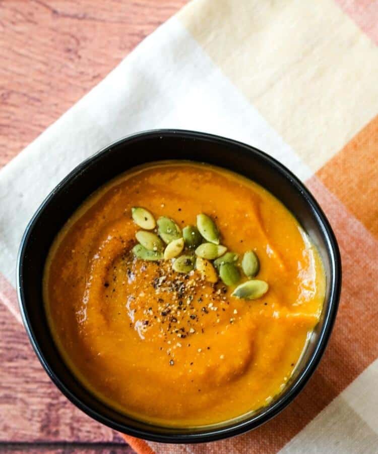 vegan pumpkin soup in black bowl on napkin
