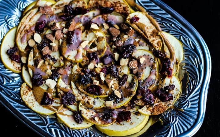 Air fryer apple nachos topped with almond butter, and dried fruit. 