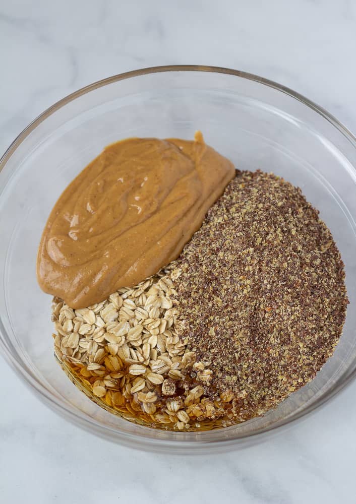 oats, peanut butter, ground flax, maple syrup in glass bowl
