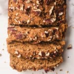Gingerbread loaf topped with pecans and sliced.