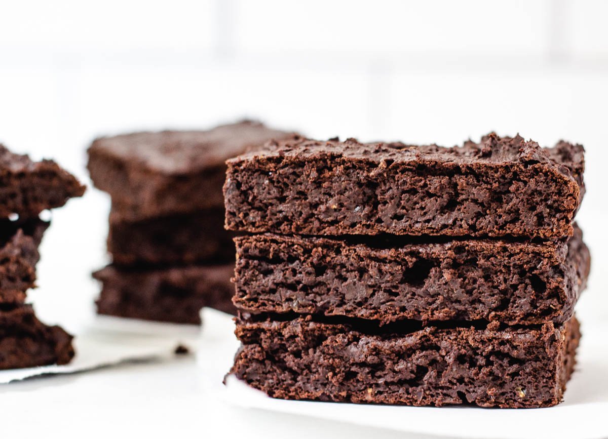 Three vegan brownies stacked on top of one another. 