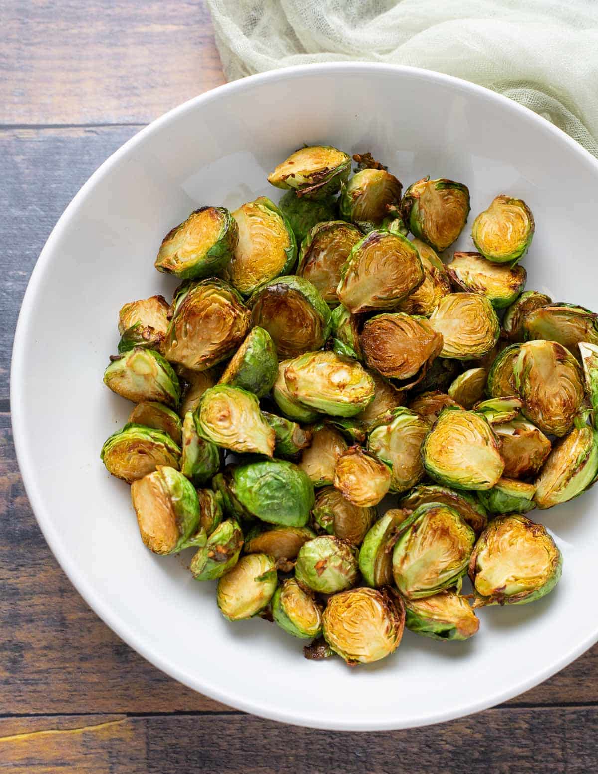 Roasted soy glazed brussels sprouts in white bowl.