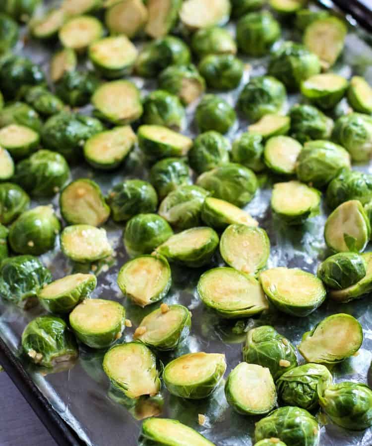 Raw brussels sprouts on baking sheet.
