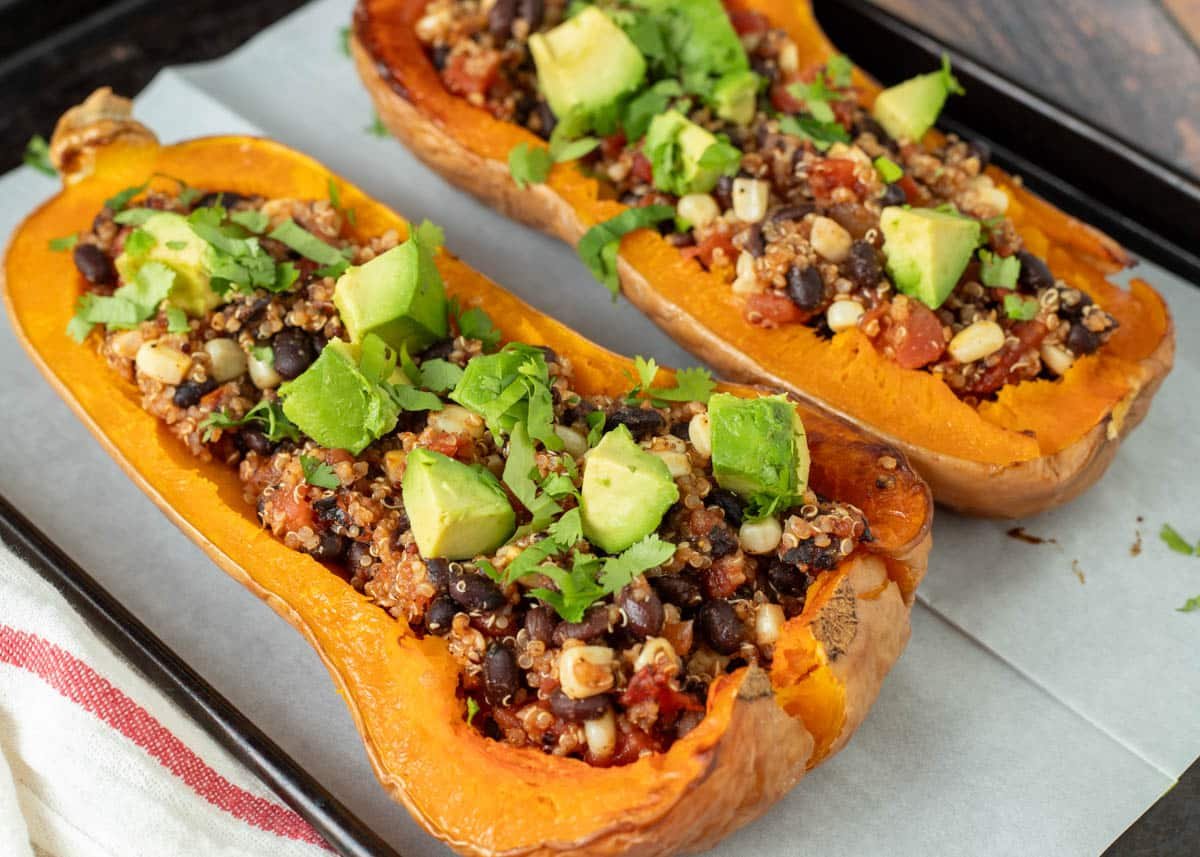 Vegan stuffed butternut squash topped with avocado and cilantro.