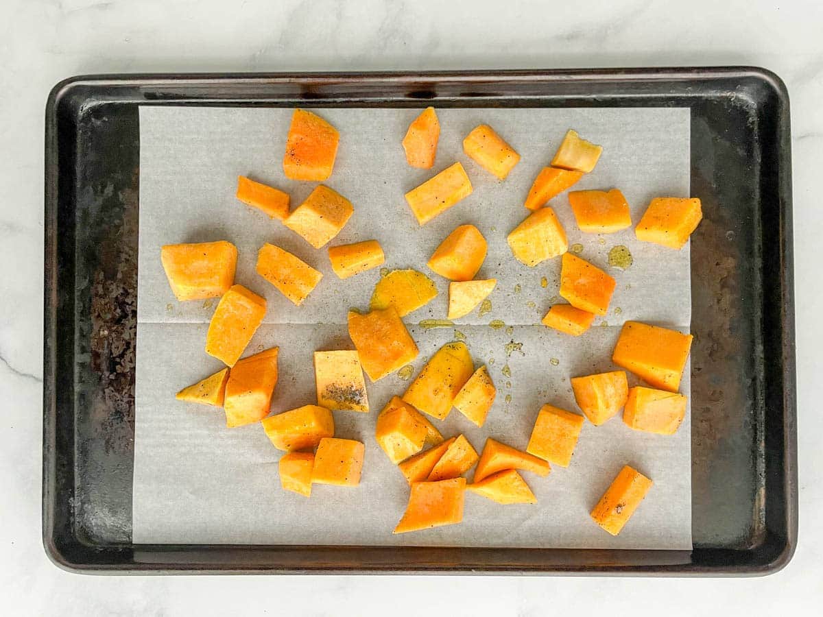 Cubed butternut squash on a baking sheet.