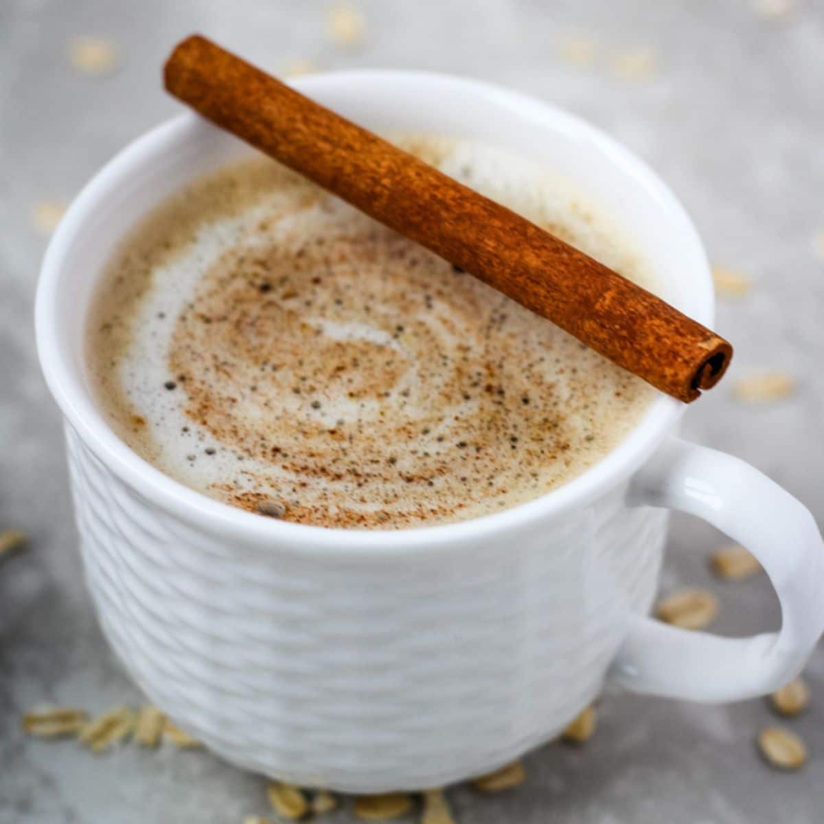 Gingerbread oat milk latte in a small white mug.