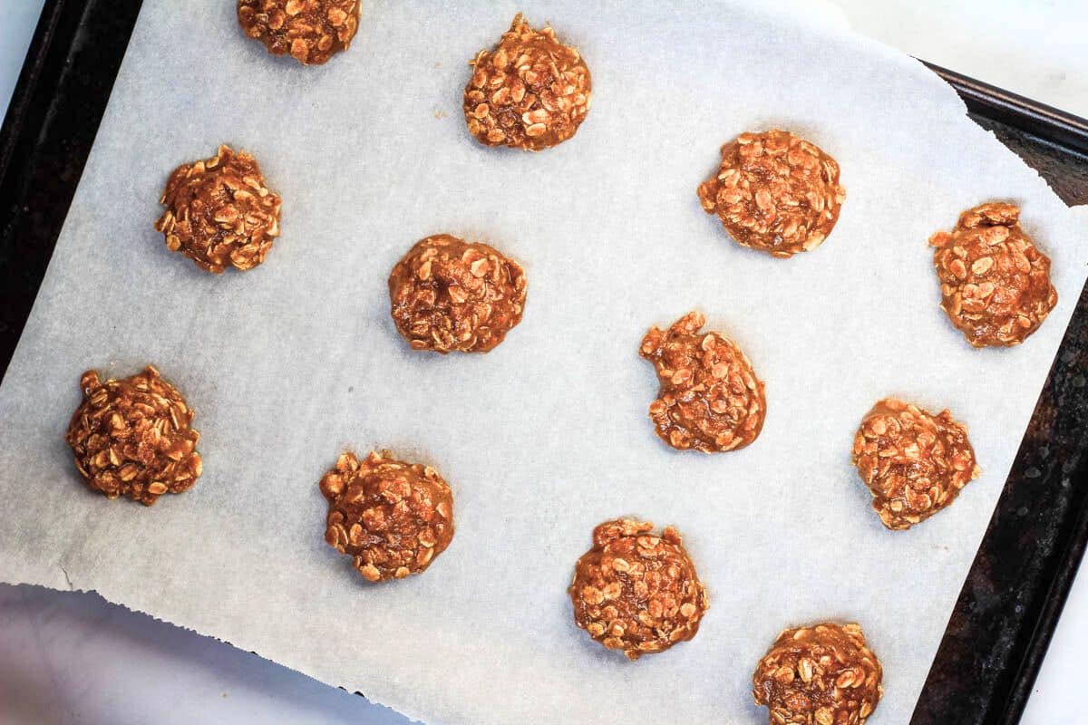 Vegan oatmeal cookie batter scoops on a baking sheet.