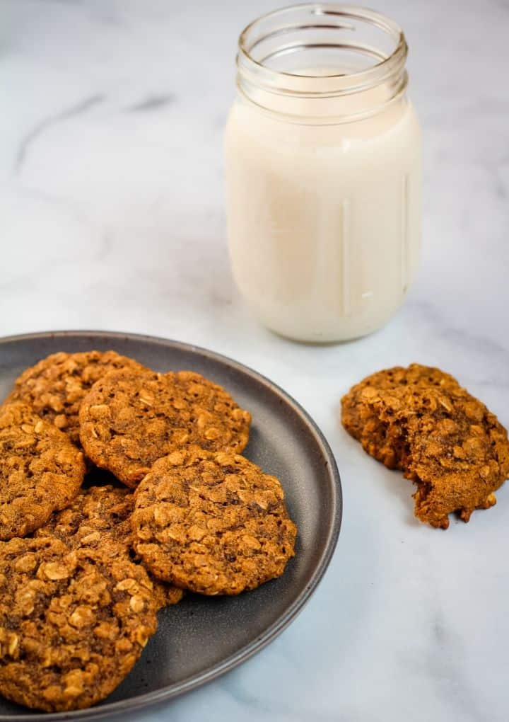 oatmeal cookies on a plate with a glass of milk in the background