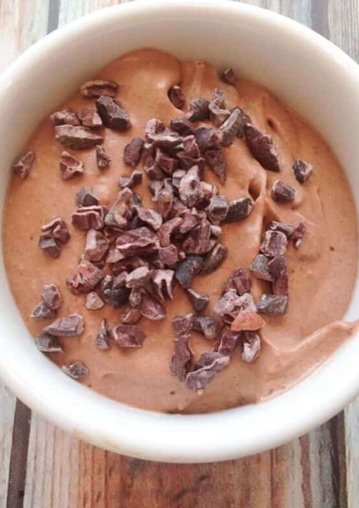 Chocolate Coconut Cream Pudding in a white bowl topped with chocolate chunks. 