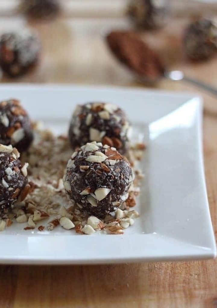 Chocolate almond truffles on white serving tray. 