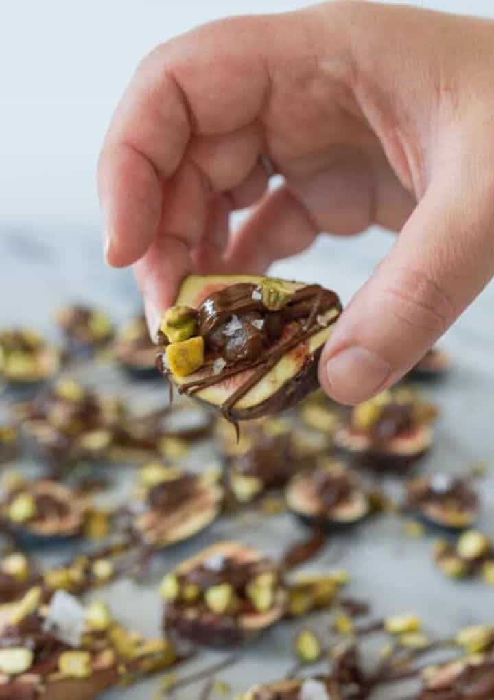 Figs topped with a drizzle of chocolate and pistachios. 