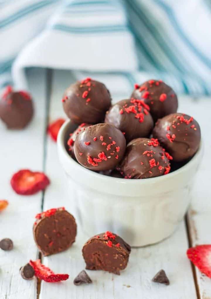 Vegan strawberry truffles stacked in a bowl. 