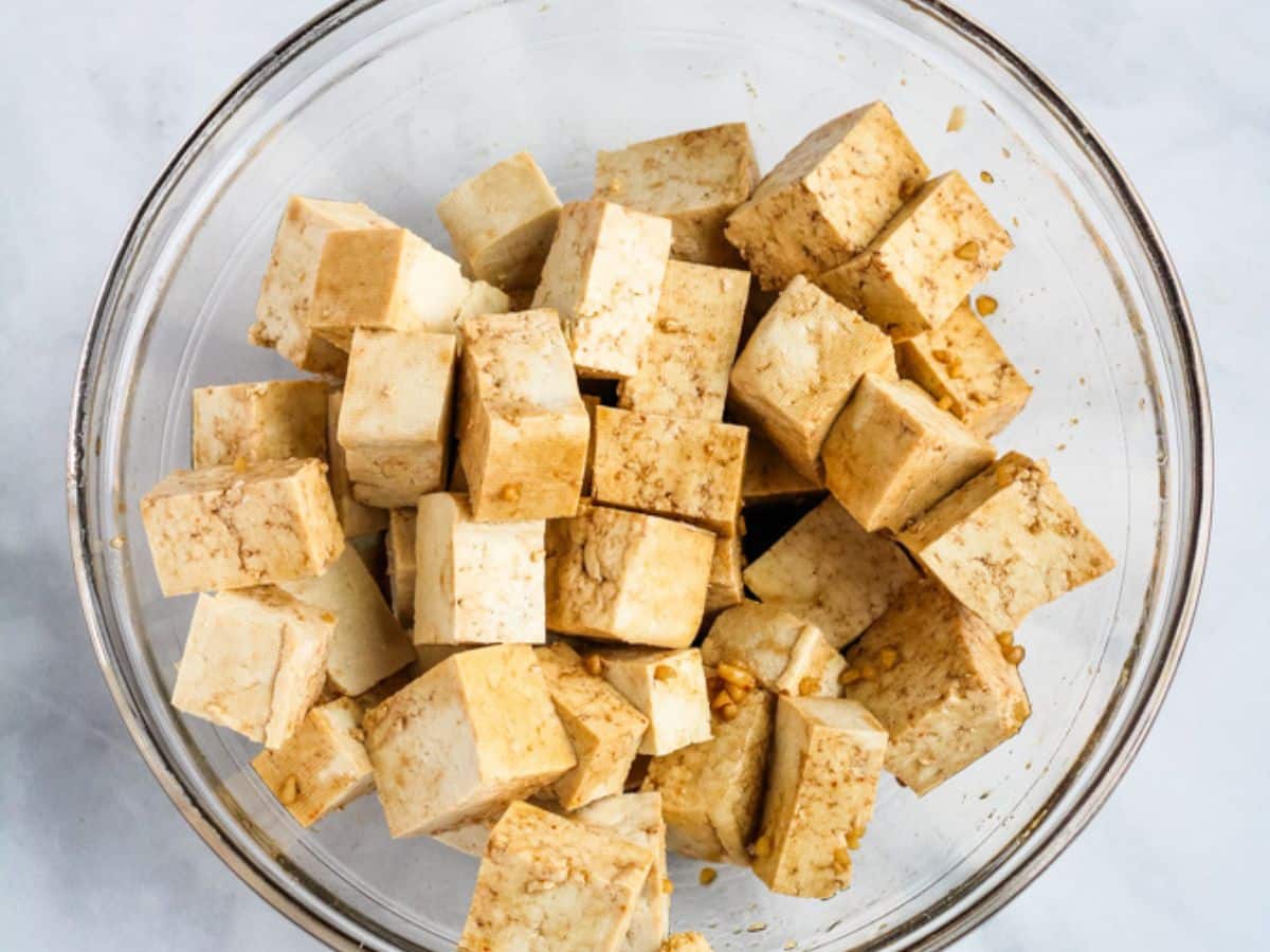 Tofu cubes marinating in soy sauce.