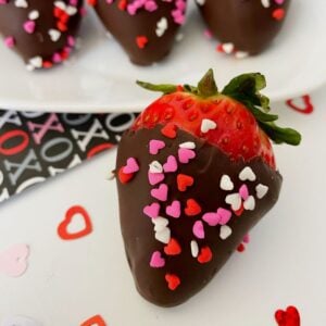 Chocolate covered strawberries with heart sprinkles.