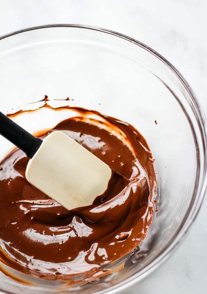 melted dark chocolate in a bowl stirred with a spatula