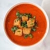 vegan tomato soup topped with croutons and basil