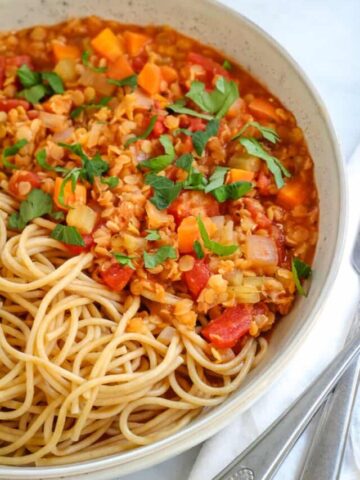 close up of lentil ragu and spaghetti in bowl