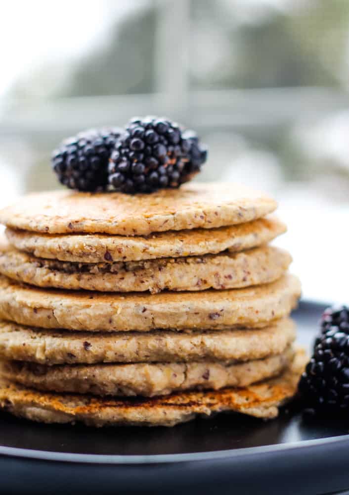 stake of vegan protein pancakes topped with blackberries