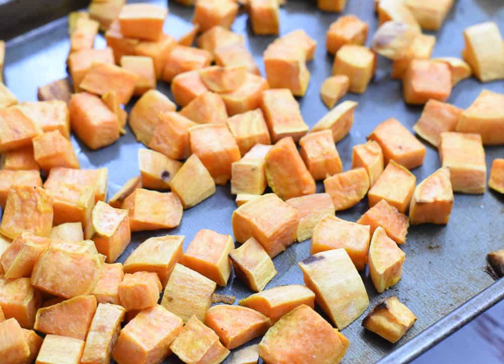 Roasted sweet potato cubes on baking sheet.