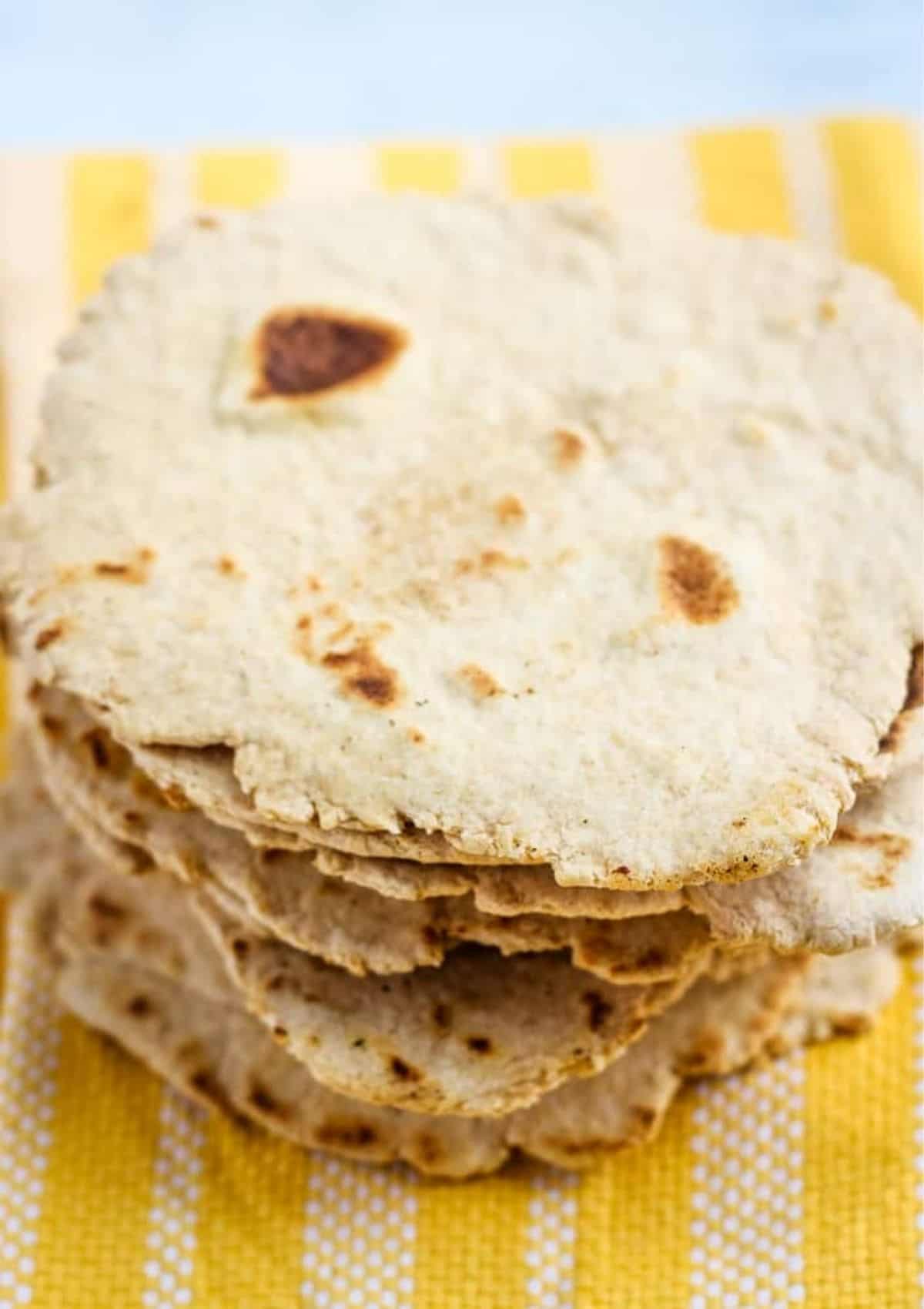 Stack of flatbreads on a yellow napkin.