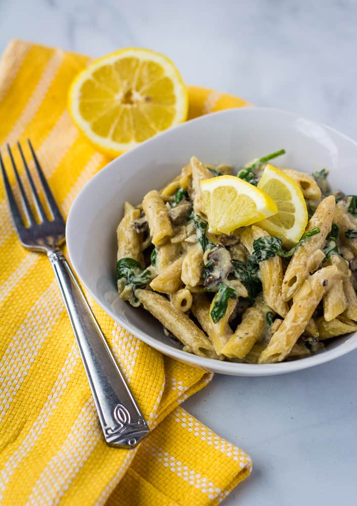 penne pasta with mushroom and spinach in white bowl
