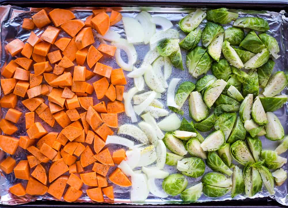 sweet potatoes, onions, and brussel sprouts on sheet pan