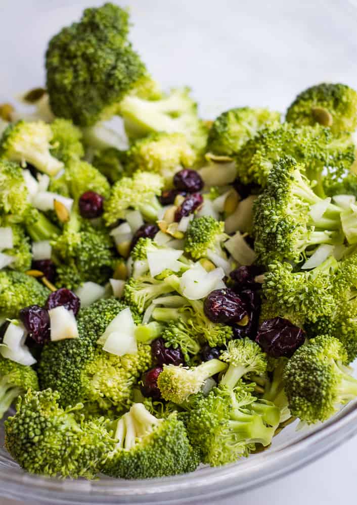 broccoli, pumpkin seeds, onion, and cranberries in bowl