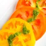 Heirloom tomatoes topped with basil sauce.