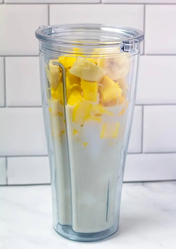 mango smoothie ingredients in large plastic cup