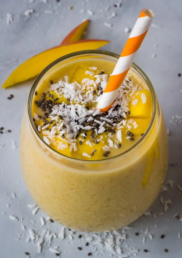 mango banana smoothie in glass with chia seed topping