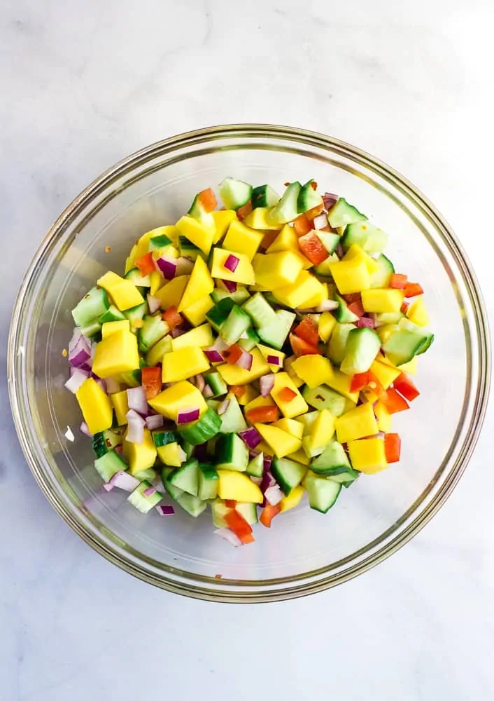 mango cucumber salad mixed together in glass bowel