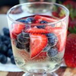 wine spritzer in glass with strawberries and blueberries