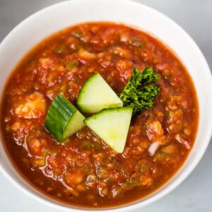 overhead of gazpacho topped with cucumber