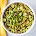 vegan potato salad with fresh herbs in white bowl