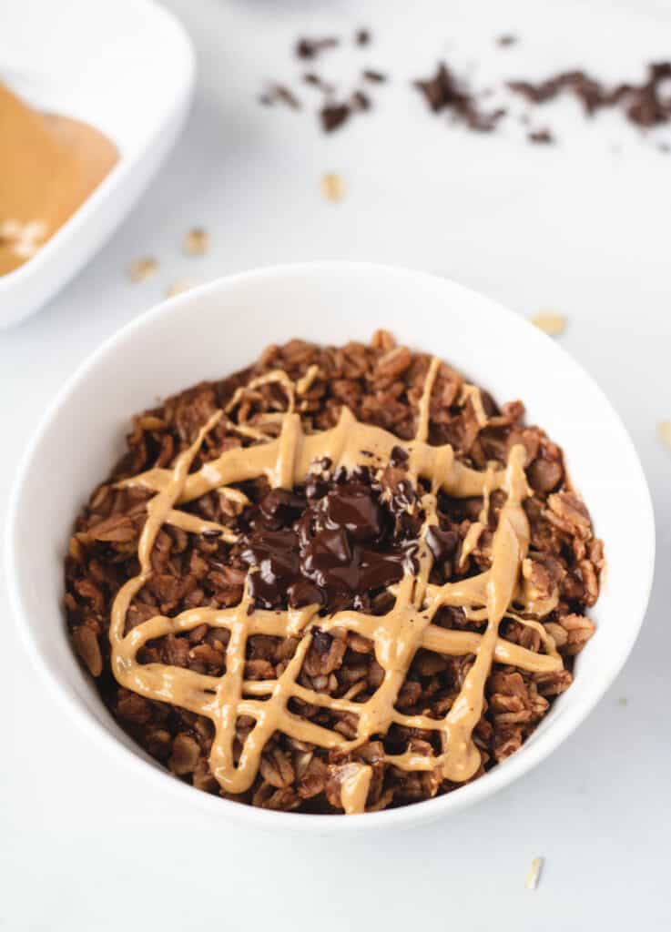 bowl of brownie oatmeal topped with peanut butter and chocolate shavings