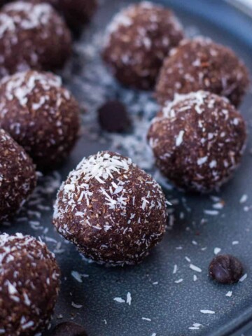 Chocolate coconut date balls on gray plate.