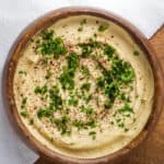 gluten free hummus in brown bowl topped with parsley