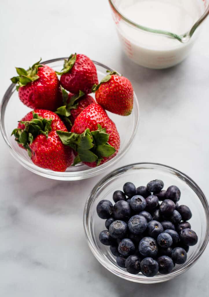 strawberries and blueberries in glass bowl