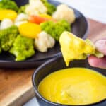 steamed broccoli dipped in vegan cheese sauce