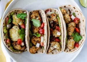 four roasted cauliflower tacos in a white bowl