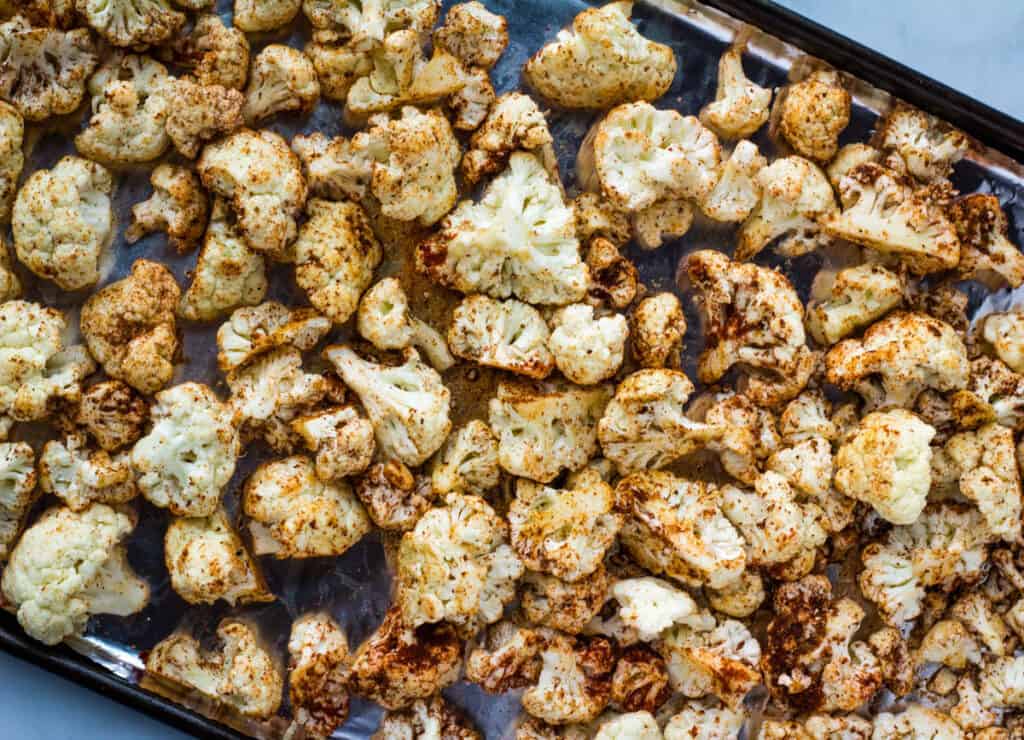 cauliflower covered in spices on baking sheet