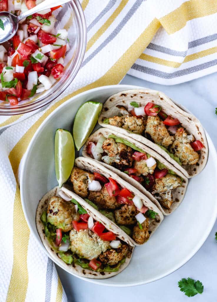 cauliflower tacos in white bowl with side of pico de gallo
