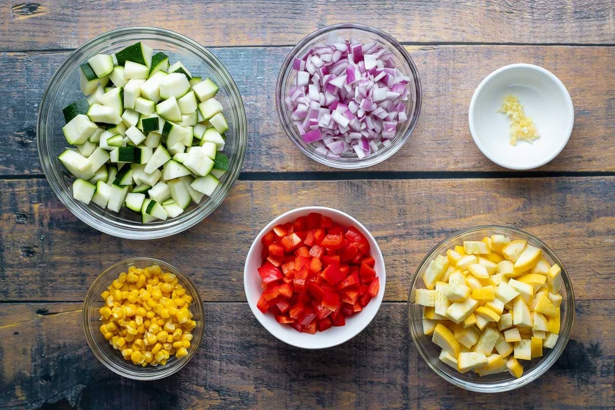 Diced zucchini, diced red onion, diced red pepper, diced yellow squash, and corn.