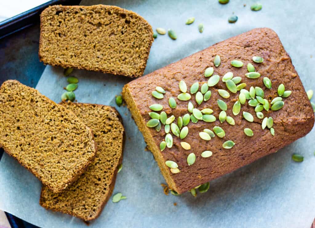 plant-based pumpkin bread loaf and three slices on serving tray