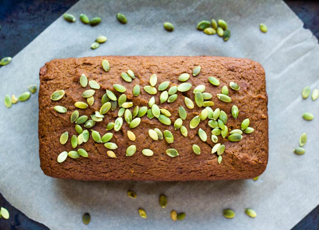 pumpkin bread loaf topped with pumpkin seeds