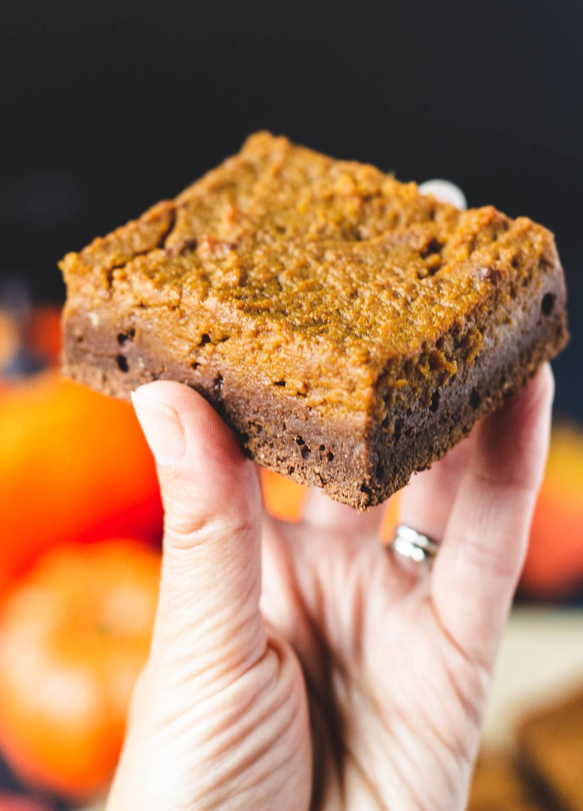 hand holding up pumpkin brownie