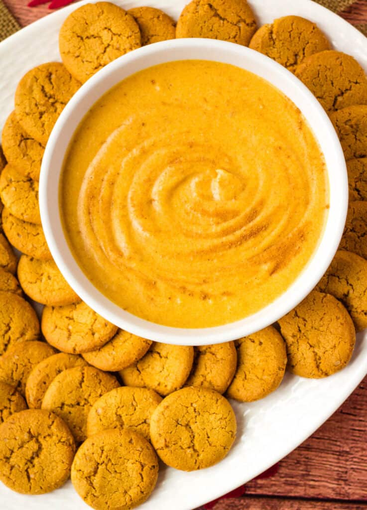 overhead of vegan pumpkin dip surrounded by cookies
