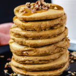 vegan pumpkin pancakes topped with nuts and syrup
